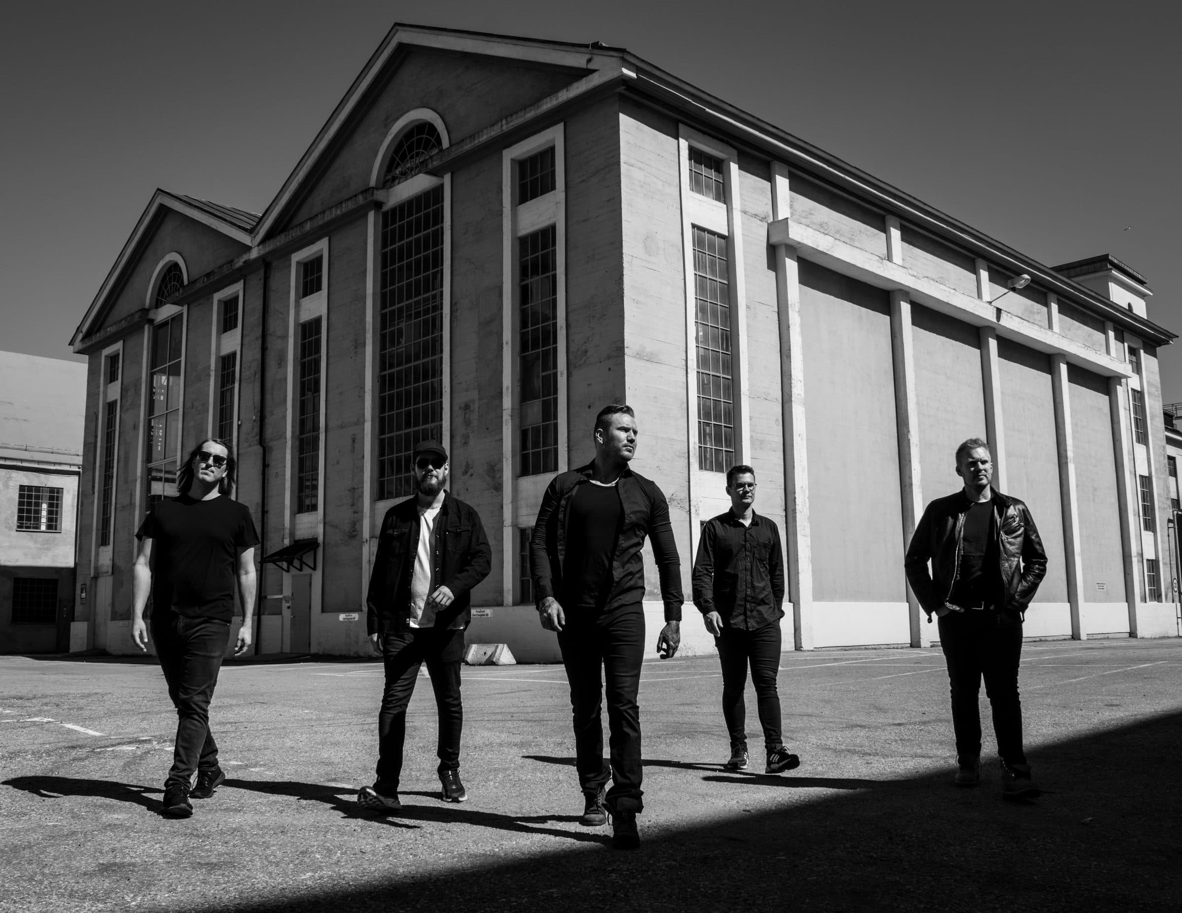 Wild Whens walking in front of an industrial hangar